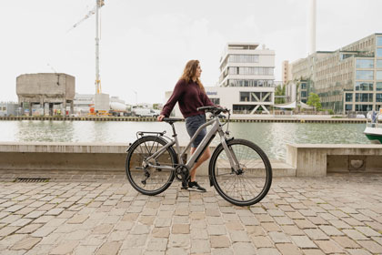 Frau mit eBike am Hafen